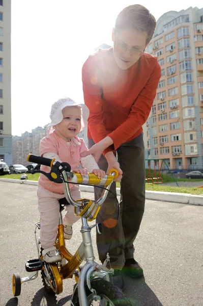 Father helping his daughter riding bicycle