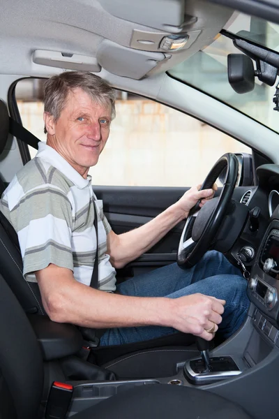 Experienced driver mature Caucasian man sitting inside of own car