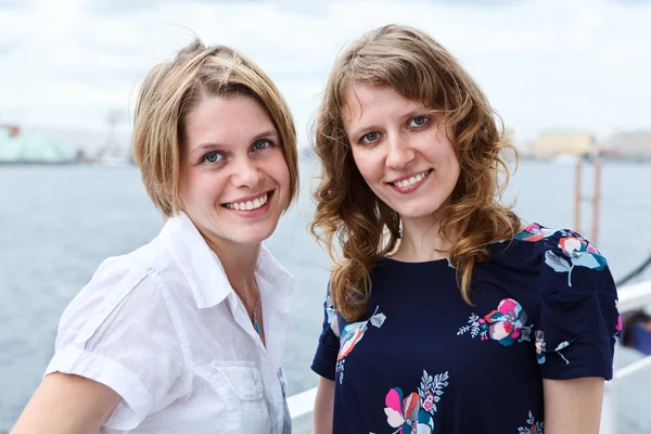 Group portrait of two beautiful women standing together on vessel deck