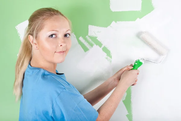 Woman paints the wall