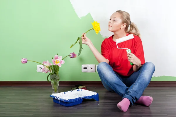 Woman with flower and paint roller in hands