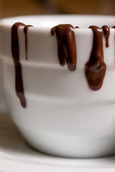 Closeup of White cofee cup with chocolate flowing