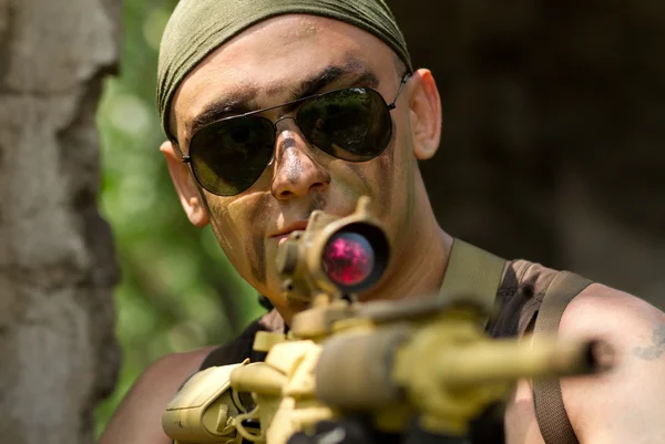 Soldier in bandana targeting with a gun
