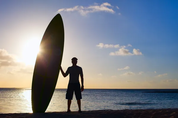 Silhouette of man with paddle board