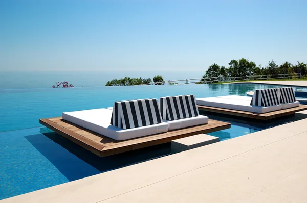 Infinity swimming pool by beach at the modern luxury hotel, Pier