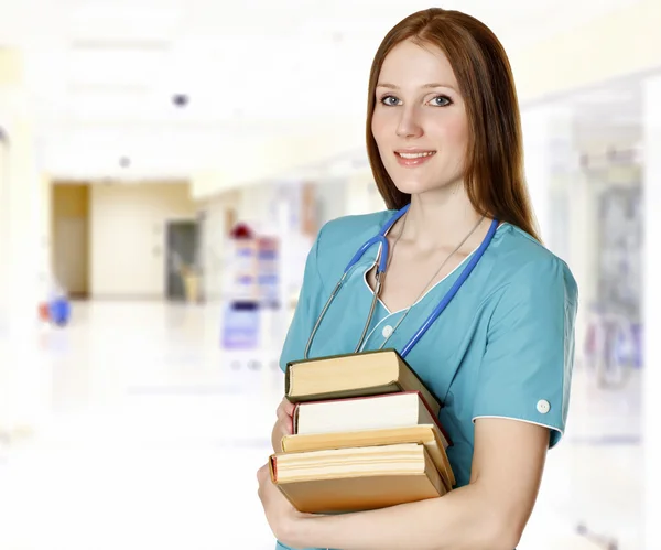 Smiling female doctor with books