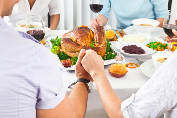 Family members giving thanks to God at festive table