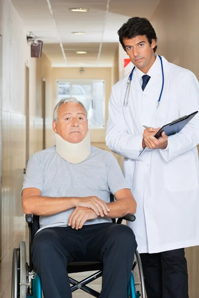 Doctor Standing By Patient On Wheel Chair