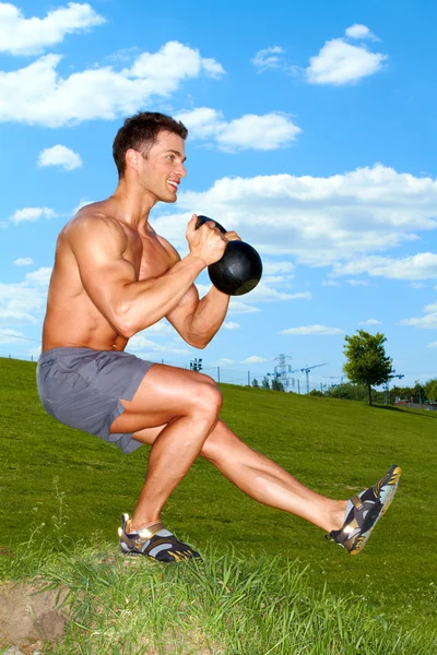 Exercises with kettlebell in sunny weather — Stock Photo #10904978