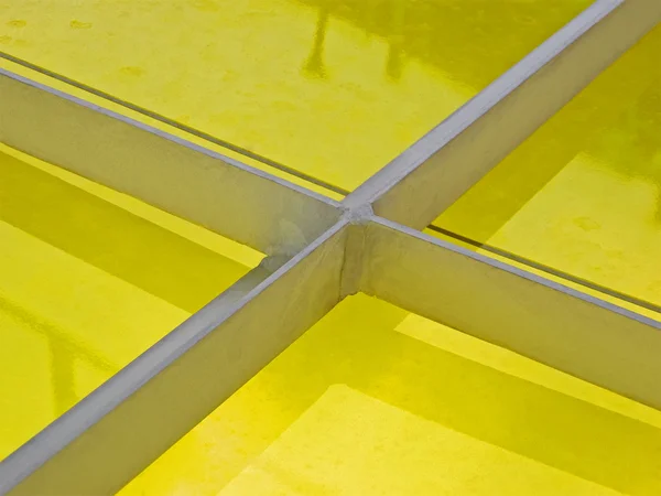Abstract metal construction covered with yellow material.