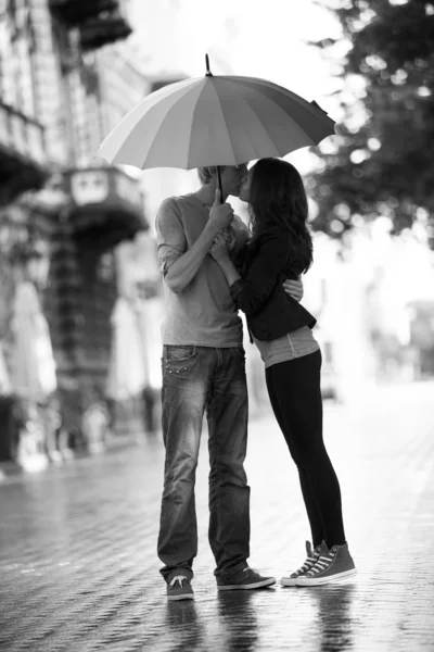 Young couple on the street of the city with umbrella