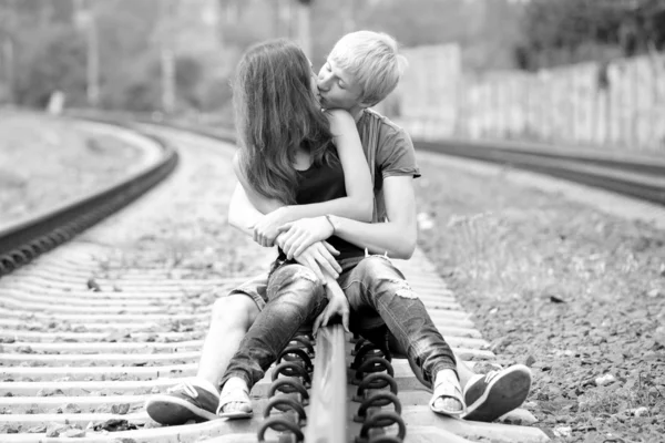 Couple kissing at railway. Urban photo.