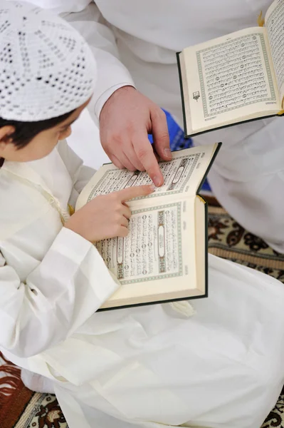 Muslim Arabic father and son reading Koran
