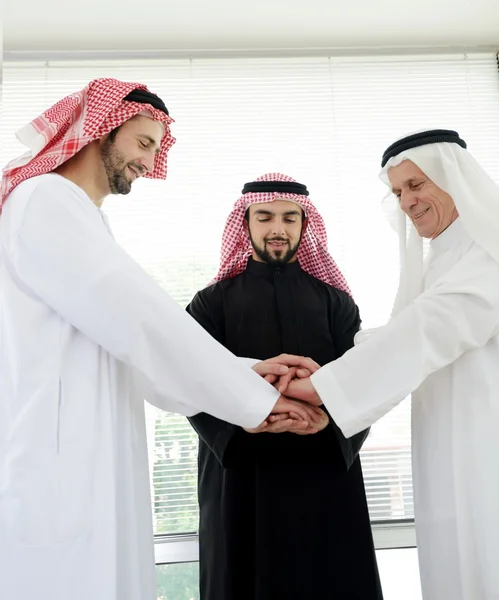 Arabic business team showing unity with their hands together