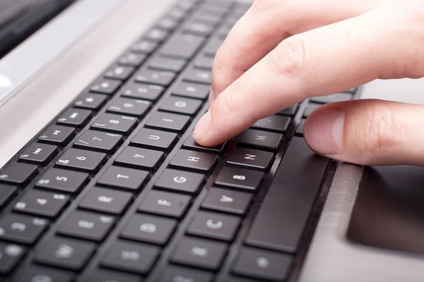 Male hand writing on laptop keyboard
