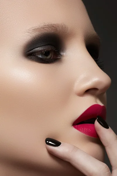 Beautiful close-up portrait of fashion woman model with glamour bright makeup, dark magenta lipstick, black nail polish. Evening catwalk style, trend visage and manicure