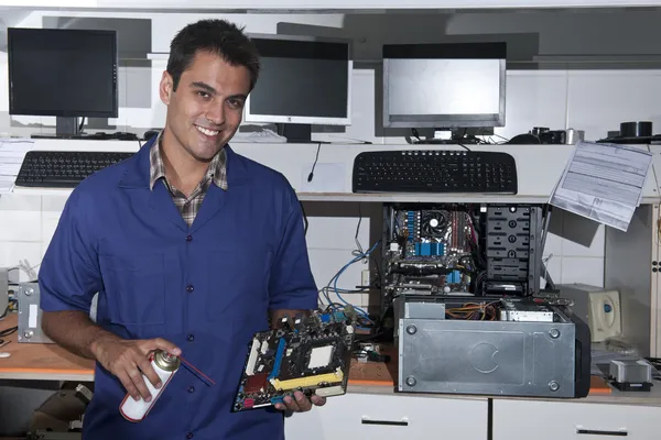 Computer technician with motherboard at workshop