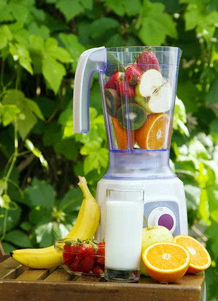 Electric blender with fruits in it