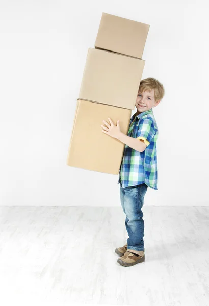 Boy holding pyramid of carton boxes. Packing up to move. Growth