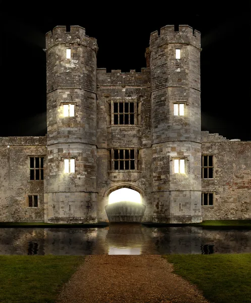 Castle at night with moat and lights shining