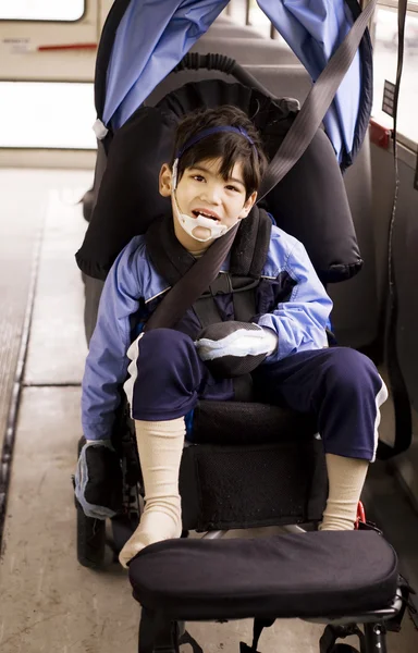 Disabled little preschool boy in wheelchair on bus