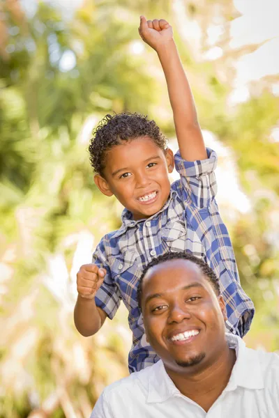 Mixed Race Father and Son Cheering with Fist in Air