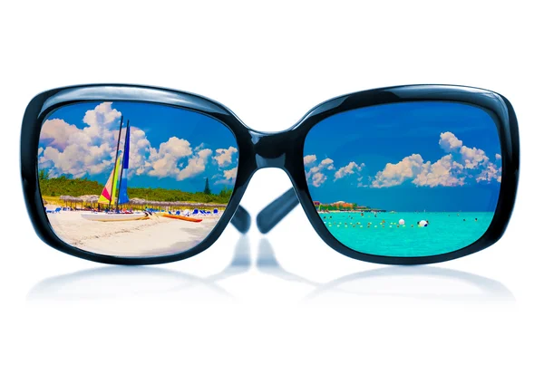 Sunglasses reflecting a tropical beach