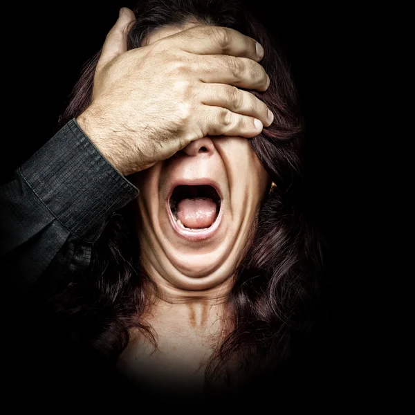 Woman screaming with a hand covering her eyes