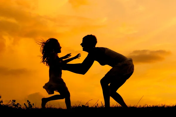 Silhouettes of mother and daughter meeting on the meadow at summer sunset — Stock Photo #12230835