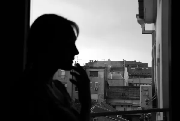 Female silhouette by window