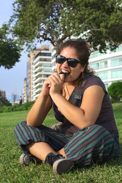 Young Peruvian Woman Biting on Mobile Phone