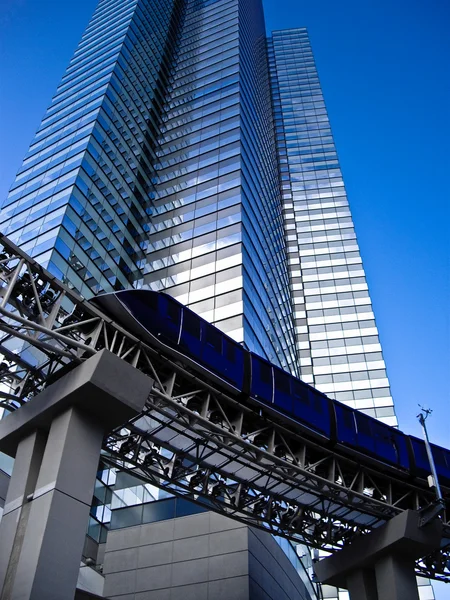 Monorail at foot of tall modern Building