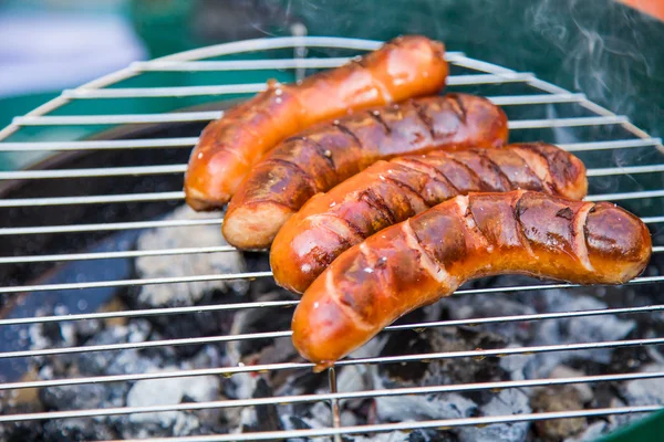Tasty sausages burning on hot barbeque