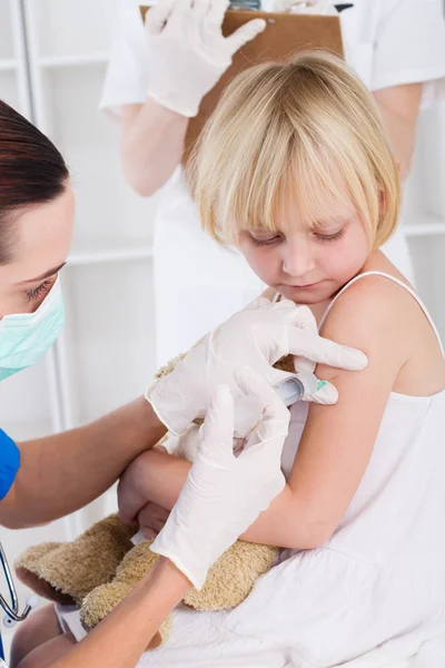 Nurse giving vaccination injection to patient