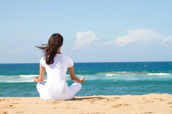 Young beautiful woman meditation on beach