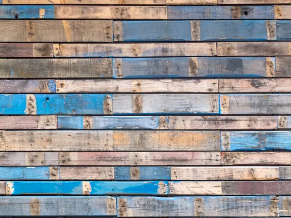Grungy blue painted wood planks of exterior siding