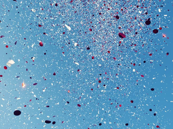 Red and White confetti against a blue sky