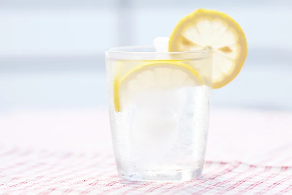 Water with lemon and lime in a glass with ice