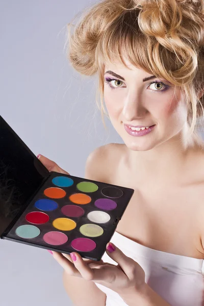 Beautiful young blond, holding eye shadow palette