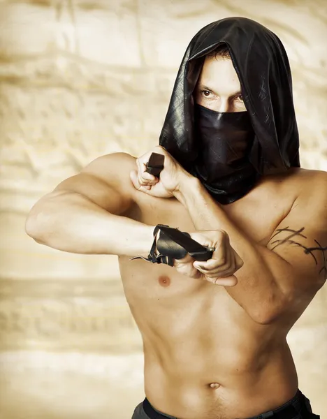 Man assassin with sexy torso in mask