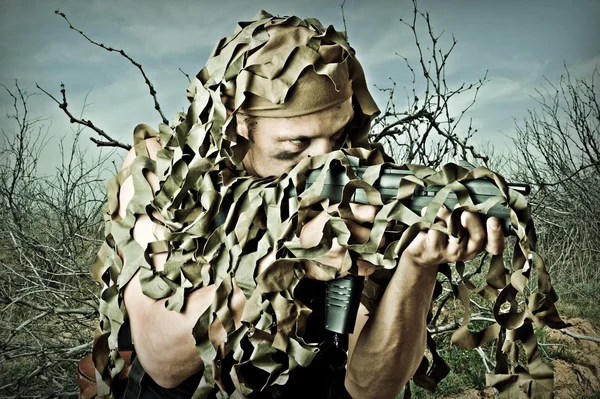 Military Camouflaged man with automatic