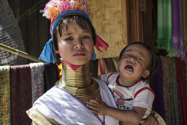 Thailand, Chang Mai, Karen Long Neck hill tribe village (Kayan Lahwi), Long Neck child and her mother in traditional costumes. Women put brass rings on their neck when they are 5 or 6 years old and in