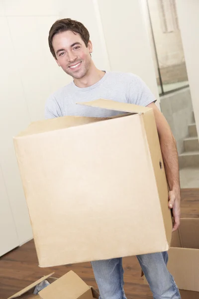 Young man on moving day holding and carrying cardboard box