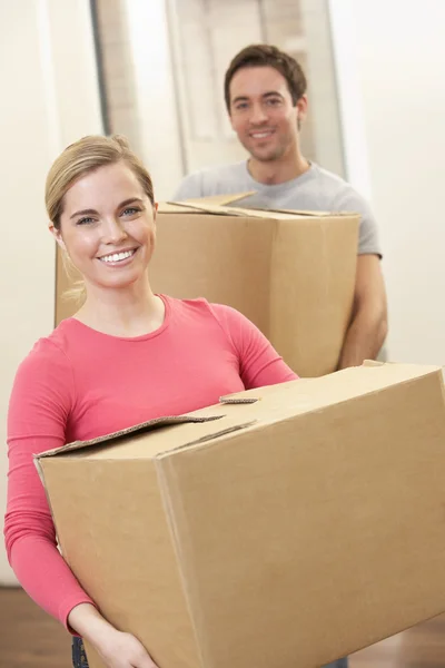 Young couple on moving day carrying cardboard boxes