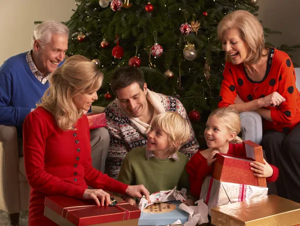 Three Generation Family Opening Christmas Gifts At Home