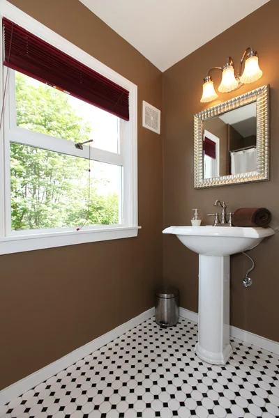 Brown small bathroom with antique sink and tiles.