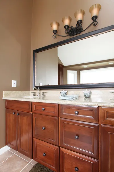 Close up luxury wood bathroom cabinets and mirror.