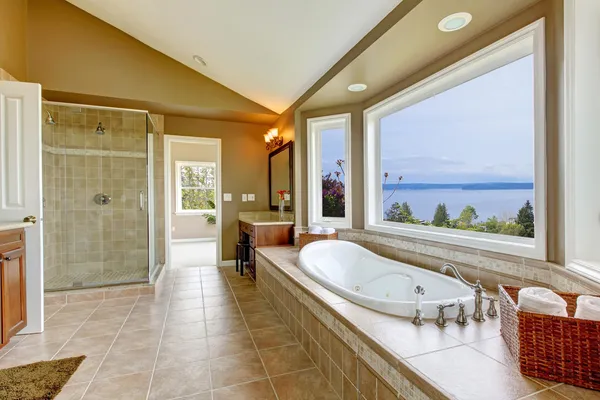 Large bath tun with water view and luxury bathroom interior.