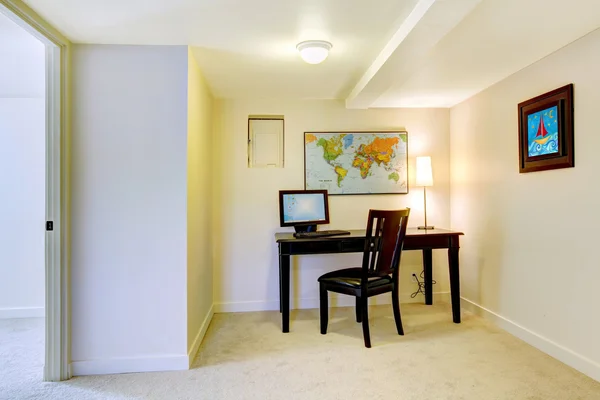 Home office desk with map on the white wall.