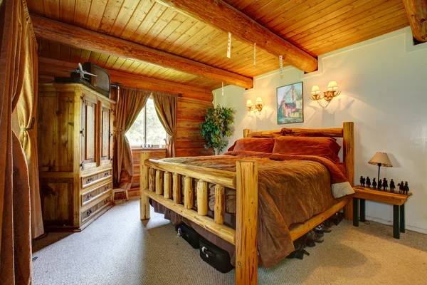 Cowboy bedroom interior with wood ceiling.